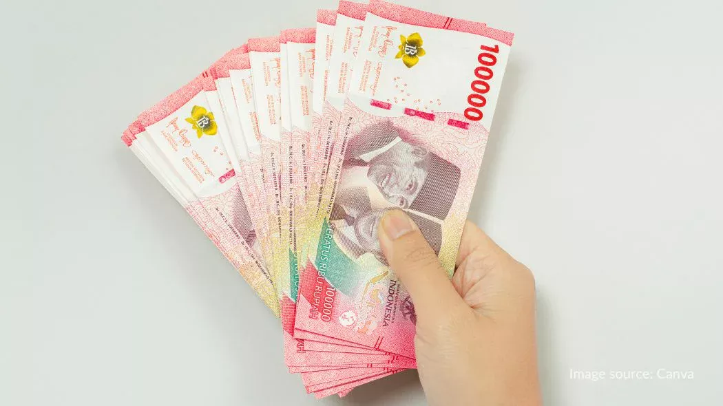 memegang sejumlah uang 100 ribu rupiah sebagai minimal saldo untuk visa korea saat pengajuan visa